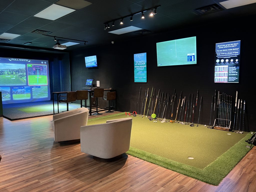 Lounge chairs and simulator bay inside One Swing Away
